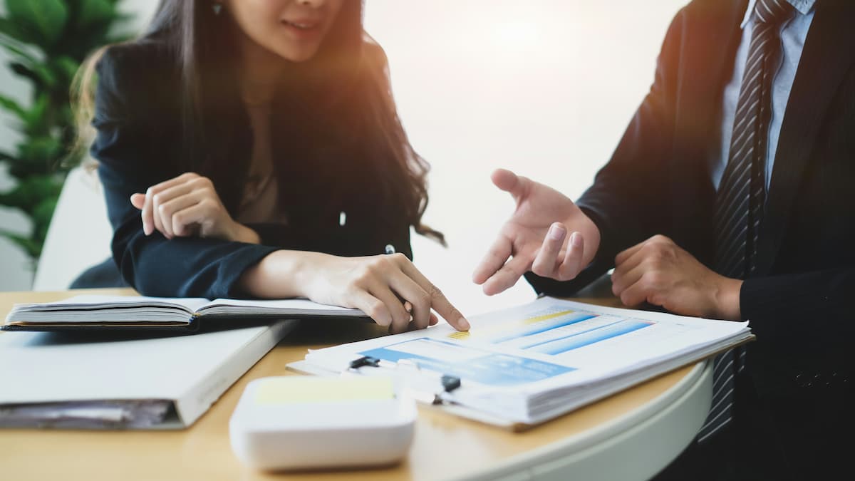 Business meeting with professionals discussing charts and reports at a table