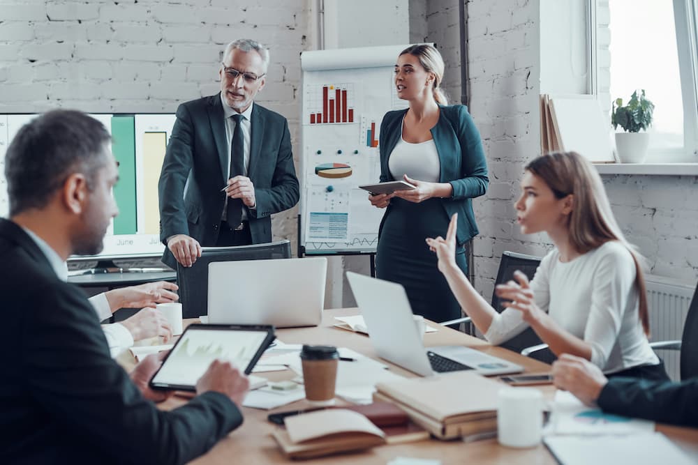 A group of lawyers are engaged in a discussion around a conference table in a modern office