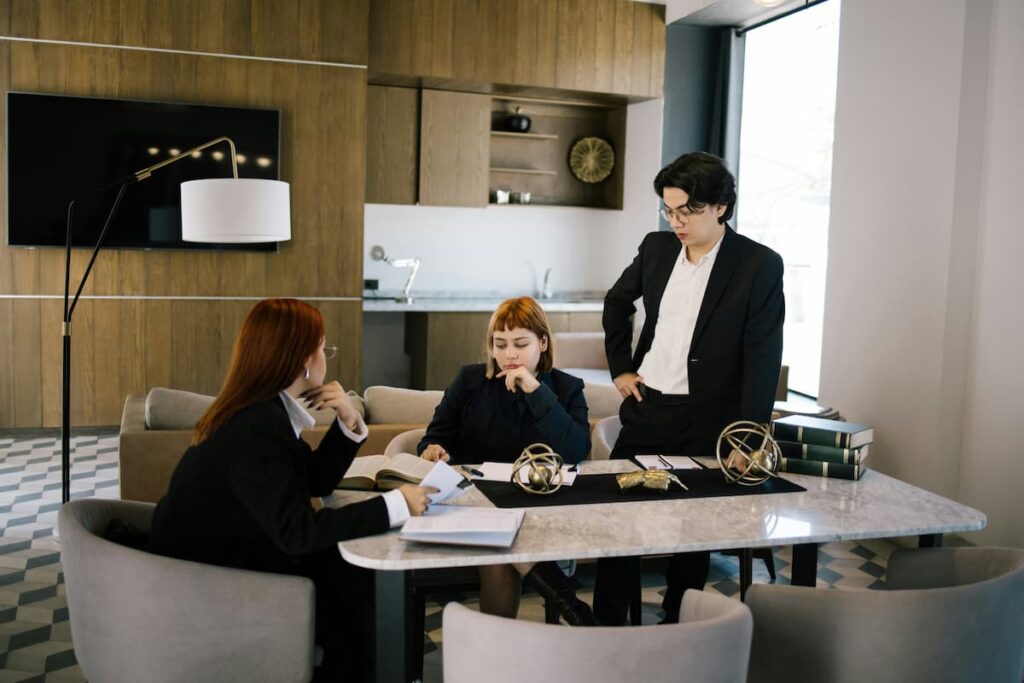 Three professionals discuss documents in a modern office, representing Legal Workflow Automation in action.