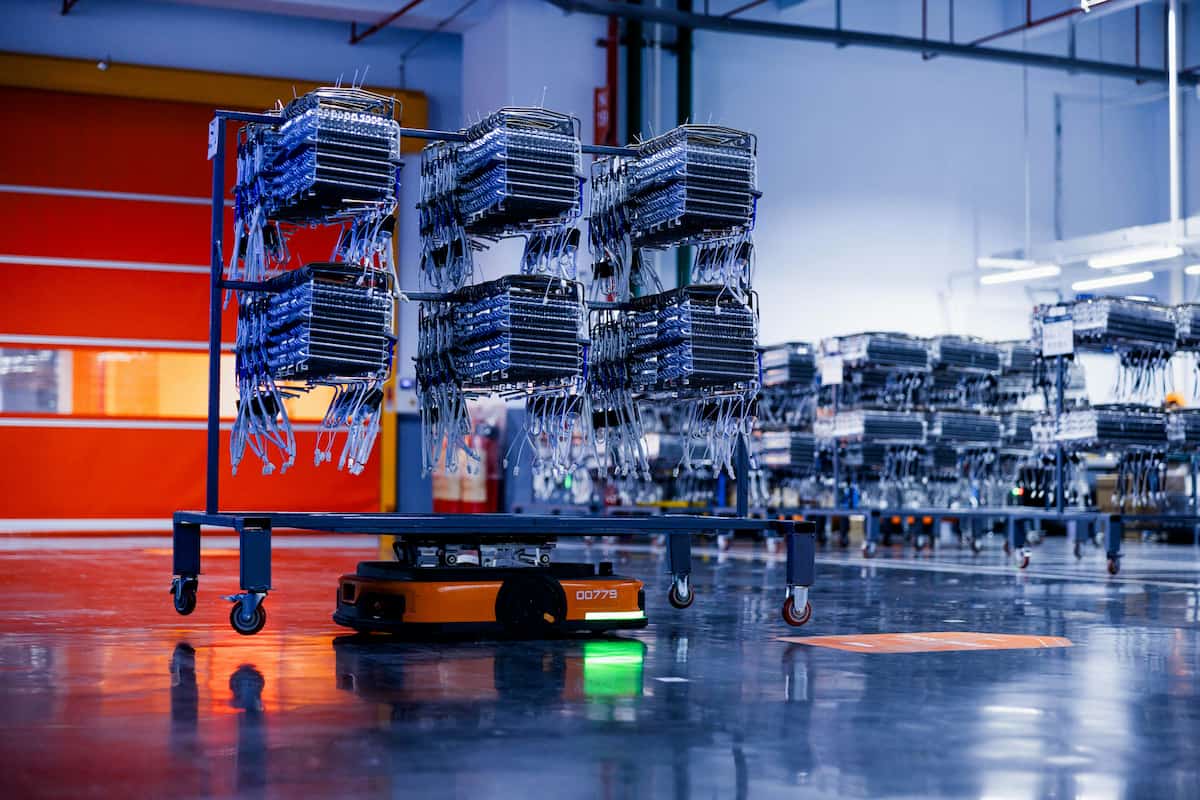 Autonomous robot moving parts in factory, showcasing smart manufacturing inventory management with automation.
